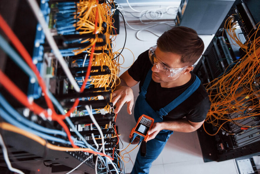 a professional electrician working on a data cabling board for a tech company in a Sydney office