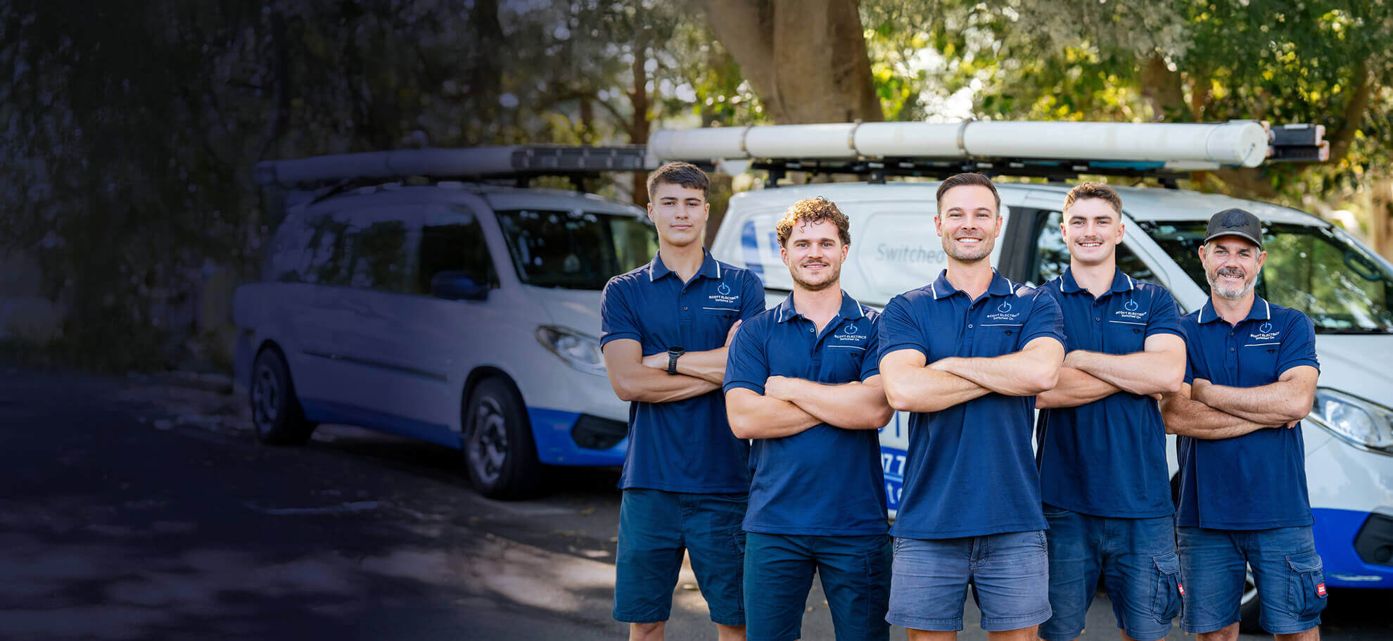 a group of five professional electricians in sydney with vans behind